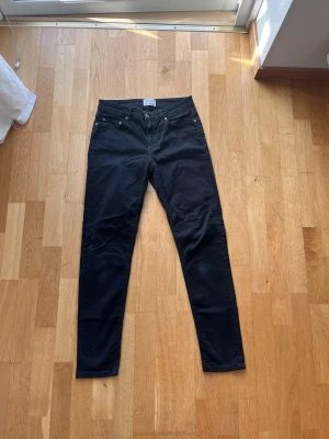 Svarta slim fit jeans från Acne studios  - Säljer ett par svarta slim fit jeans från Acne  studios  med klassisk femficksmodell och dragkedja. Jeansen har raka ben och är tillverkade i ett stretchigt bomullsmaterial för skön passform. Perfekta för dig som gillar en enkel och stilren look.