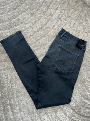 Replay hyperflex Anbass Jeans  - Replay hyperflex Anbass jeans, färgen är lite blå/grå/grön aktig och färgen har ljusats upp vid framfickorna och gylfen - se närbild. Midja 45cm, längd 114cm. JAG SKICKAR EJ FLER BILDER NÄR JAG BÄR JEANSEN! för bättre inblick i passformen rekommenderar jag att googla på modellnamnet. För storleksguide kolla måtten noggrant då jeansen alltid kan vara uppsydda heller krympta och jag ej tar emot returer :) 1,91