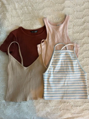 Fyra stycken toppar  - Fyra croppade toppar, perfekta för sommaren! Alla är i storlek XS: en randig topp från BikBok, en beige linnetopp från H&M, en brun crop top från Shein och en ljusrosa tank top från H&M. Perfekta för soliga dagar och till vardags 