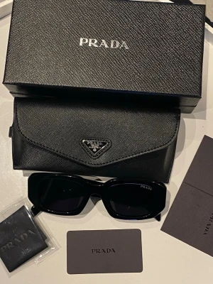 Svarta solglasögon  - Helt nya och använda svarta prada solglasögon som passar för både män och kvinnor. Kommer med allt som finns med i bilden💕💕 tveka inte o fråga💗