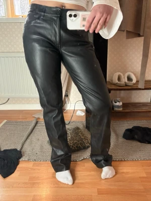 Svarta raka skinnbyxor - Säljer ett par svarta skinnbyxor med rak passform och hög midja.