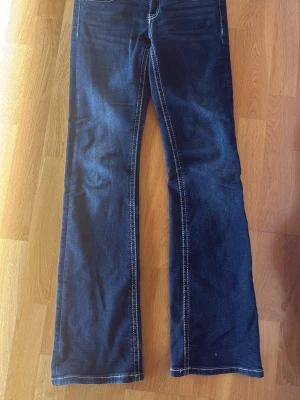 Mörkblå lågmidjade bootcut jeans  - Säljer ett par mörkblå bootcut jeans. Storlek 158, men passar mig som är 164. Säljs på grund av att de inte används längre. Pris kan diskuteras vid snabb och smidig affär💕