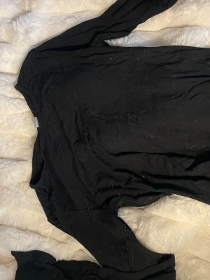 Svart långärmad topp i bomull - En basic svart långärmad topp med rund halsringning. Tillverkad i mjuk bomull, perfekt att styla med jeans eller kjol. Enkel och tidlös design som funkar till många olika looks.är även vid i armarna😍