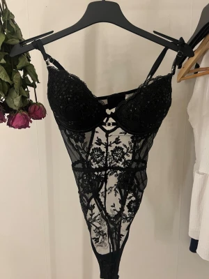Spets body - Svart spetsbody i mesh och blom detaljer i paljettform, strl S kupa 75C