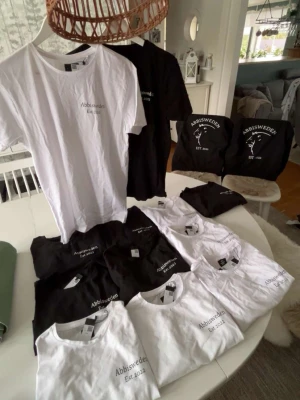 Svart och vit t-shirt Abbisweden - Säljer flera stilrena t-shirts från Abbisweden i svart och vitt med trycket 'Abbisweden Est. 2022' på bröstet. Klassisk rund hals och korta ärmar, perfekt till jeans eller shorts. Finns både i svart och vit, enkel och clean design.