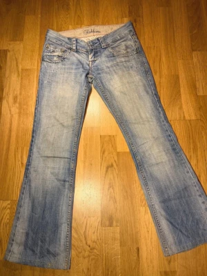 Fishbone - Superfina fishbone jeans i färgen ljusblå! Egen knapp sydd.   Midjan: 37 cm midjehöjd: 18 cm Innerbenslängd: 73 cm