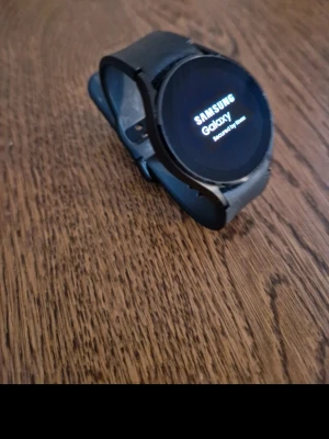 Samsung Galaxy Watch svart - Snygg svart Samsung Galaxy Watch med rund urtavla och silikonarmband. Klockan har en modern design och tydlig display, perfekt för dig som vill ha koll på både notiser och hälsa direkt på handleden. Passar 20mm armband och har pulsmätare på baksidan.