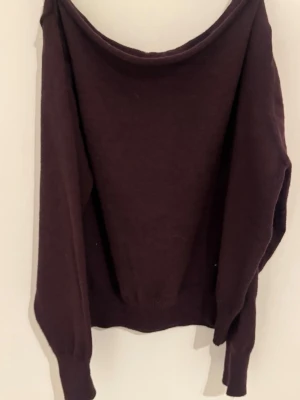 Mörklila stickad tröja - En enkel och stilren mörklila stickad tröja med rund halsringning och långa ärmar. Tröjan har ribbstickade muddar vid ärmslut och nederkant, vilket ger en snygg passform. Perfekt för lager på lager och passar till det mesta.