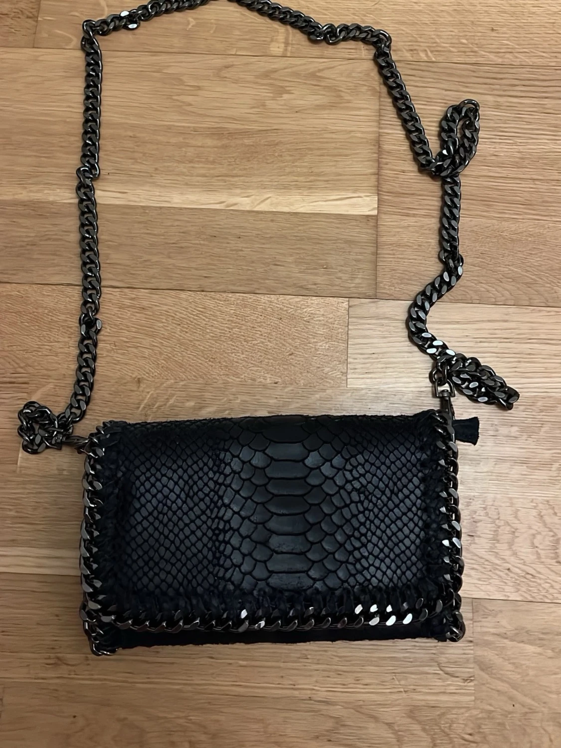 Svart axelväska med kedja och ormmönster