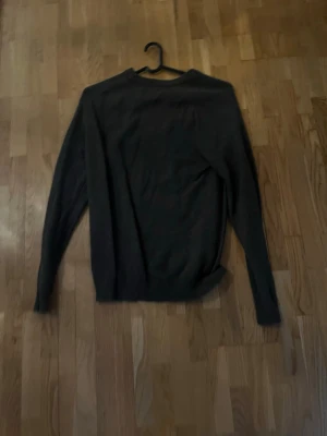 Mörkgrå stickad tröja Only & Sons - Säljer en mörkgrå stickad tröja från Only & Sons. Tröjan har rund halsringning, långa ärmar och ribbade muddar vid ärmslut och nederkant. Perfekt för lager på lager och enkel att matcha med olika outfits.