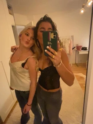 Svart korsett med push-up - Snygg svart korsett med markerade vita sömmar och smickrande passform. Toppen har smala axelband och en croppad design som framhäver midjan. Perfekt för att lyfta vilken outfit som helst.