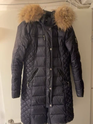 Rock and blue jacka - Säljer nu min rock & blue jacka då den blivit för liten. Det är den längre modellen och den har äkta päls. Den har två små hål som inte direkt syns och har spruckit i innerarmen men inget som stör (lätt att laga). Den har två fickor fram samt en bröstficka, den har en liten ficka på armen och även två innerfickor en stor/djup och en lite mindre. Är man intresserad så kan jag skicka fler bilder!