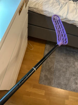 Unihoc evolabe 96 flex 29 - Säljer en innebandyklubba från Exel med svart skaft och ett lila plastblad. Skaftet har märkningen 'Evolabe och klubban har en modern design som passar perfekt för innebandyspel. Bladet är lätt böjt för bättre bollkontroll. Ny pris e 2600