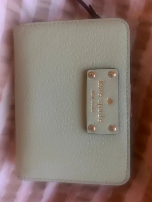Kate Spade Plånbok - Mintgrön plånbok från Kate Spade. Små sprickor på insidan men annars i gott skick!