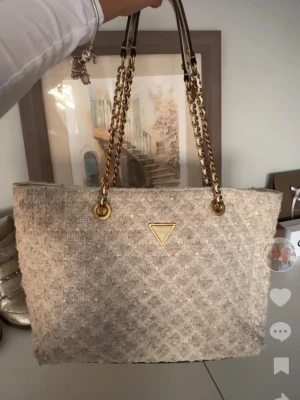 guess väska - vit stor quiltad guess väska. välanvänd vilket syns på färgen som ändras på både utsida och insida. fortfarande fin :) pris går att diskutera och har rabatter vid köp av bundles 💓