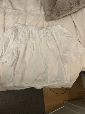 Vit offshoulder blus från Kappahl - Säljer en luftig vit offshoulder blus från Kappahl i storlek XS. Blusen har resår upptill och är tillverkad i ett tunt bomullstyg med diskret randigt mönster.💞