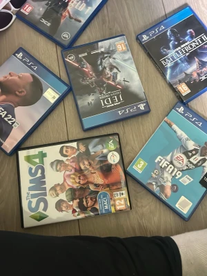 Samling PS4-spel och The Sims 4 - Säljer en samling spel till PlayStation 4 och PC/Mac: FIFA 22, FIFA 19, Star Wars Jedi: Fallen Order, Star Wars Battlefront II och The Sims 4. Spelen har blå plastfodral för PS4 och The Sims 4 har ett vitt fodral. Perfekt för dig som gillar sport, äventyr och simulering.