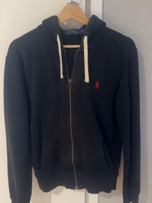 Ralph lauren tröja  - Säljer en svart Ralph Lauren hoodie som har solblekts lite i mitten av tröjan och på luvan. Utöver det är den i bra skick.