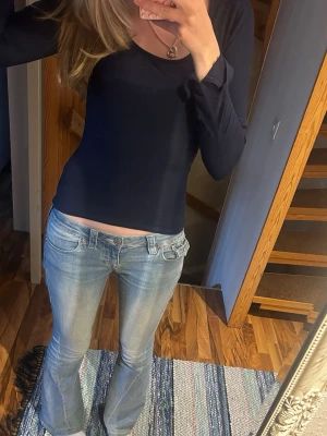 Mörkblå långärmad topp Gina tricot  - En enkel och stilren mörkblå långärmad topp från Gina tricot. Modellen är figurnära med rundad ringning och mjukt, stretchigt material som känns skönt mot huden. Perfekt att matcha med jeans eller kjol. 