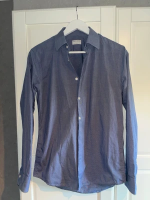 Blå skjorta från Tiger of Sweden - Blå mönstring skjorta från Tiger of Sweden i storlek 38, slim fit. Nyskick. Säljs på grund av för liten storlek.