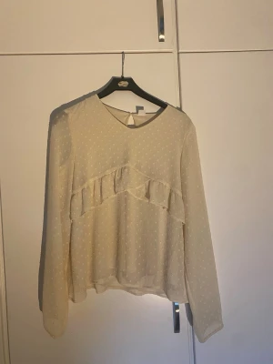 créme färgad blus med volang - Jättefin blus i nytt skick! Perfekt för en trendig och feminin look.