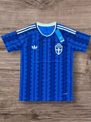 Blå Sverige fotbollströja Adidas - Snygg blå fotbollströja från Adidas med Sveriges landslagsemblem på bröstet och vita detaljer. Tröjan har ett unikt mönster, klassiska tre ränder på axlarna och rund halsringning. Tillverkad i lätt och funktionellt material, perfekt för träning eller match.