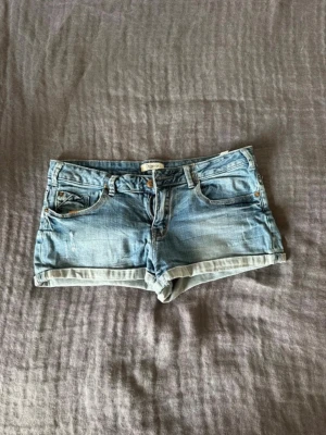 Blå lågmidjade jeansshorts - Säljer ett par snygga blå jeansshorts med låg midja. Shortsen har skön passform och perfekt material!