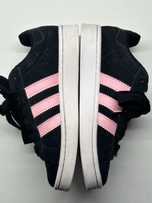 Adidas campus 00s - Säljer dessa svarta campus med rosa stripes i storlek 38❣️använd fåtal gånger, väldigt bra skick!