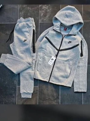 Gråa Nike Tech Fleece full set  - Säljer ett par gråa Nike Tech Fleece mjukisbyxor med svarta detaljer och dragkedjor. Byxorna har resår i midjan med snörning och muddar vid bensluten. Perfekta för chill eller träning, riktigt sköna och stilrena. Pris kan diskuteras!