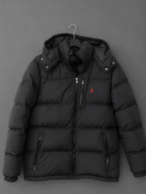 Svart pufferjacka från Polo Ralph Lauren - Säljer en svart pufferjacka från Polo Ralph Lauren med huva och dragkedja framtill. Jackan är i bra skick, inga hål eller liknade. Pris kan diskuteras 