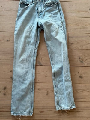 Ljusblå raka jeans från Zara - Ljusblå jeans från Zara i rak modell med klassisk femficksdesign. Jeansen har råa, fransiga benslut och är tillverkade i denim. Perfekta för en avslappnad och trendig look.