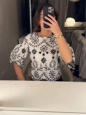 Zara blus  - Broderad topp från Zara (Trafaluc) 🤍 Storlek M passar XS/S  Superfin svart/vit brodyr och vida ärmar. Sitter jättefint och är perfekt till fest, middag eller sommar.  Fint skick. Finns ej att köpa längre och är väldigt efterfrågad! 
