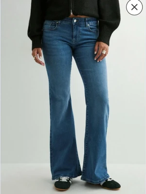 Blå lågmidjade bootcut jeans från ONLY - Säljer ett par klassiska blå bootcut jeans från ONLY med låg midja och fem fickor. Jeansen har en snygg utsvängd passform och är tillverkade i stretchigt denimtyg för extra komfort. Perfekta för en trendig och avslappnad look. Stl xs, endast testade en gång. Nypris 559kr