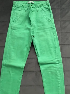 Gröna jeans - Snygga gröna jeans. Jeansen har klassiska fickor fram och bak samt bälteshällor. Perfekta för dig som vill sticka ut med färg i din outfit. Materialet känns mjukt och bekvämt, troligen bomull.