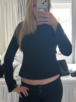 Svart topp - Svart långärmad topp med croppad passform och lätt utsvängda ärmar, ryggen har en unik knytning 🙌🏼 Tröjan är från Gina och ör helt ny med prislapp 💗Skriv vid frågor eller prisförslag 🥰