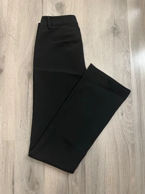 Vera Tall Flared Kostymbyxa - Snygga trendiga kostymbyxor med bootcut passform från BikBok. Dragkedja och knapp. Säljer då de sitter lite löst i midjan på mig som vanligtvis är 34. Använda endast 1 gång. 🌸Nypris: 499:-