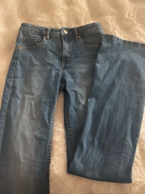 Ljusblå raka jeans i denim - Säljer ett par ljusblå jeans med bootcut. Jeansen är low-midwiast och är hyfsat stretshiga. Perfekta för en avslappnad och trendig look. De är från Kappahl i storlek 164 vilket motsvarar xs och passar någon som är 160 ungefär. Jag köpte dessa för 499kr som referens💕helt oanvända