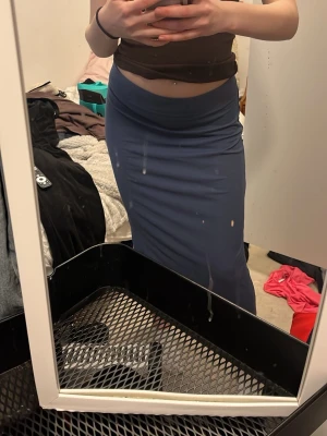 Blå långkjol i stretchigt material - Snygg blå långkjol med figurnära passform och hög midja. Kjolen är enkel och stilren utan mönster eller detaljer, perfekt för en clean look. Materialet känns stretchigt och bekvämt.