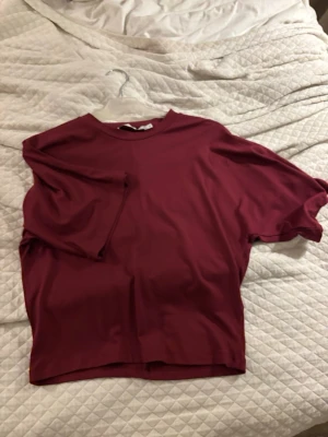 Vinröd t-shirt från 157 - Enkel och stilren vinröd t-shirt från 157 med rund halsringning och normal passform. Perfekt basplagg till garderoben och lätt att matcha med olika stilar. Tillverkad i mjukt material för skön känsla hela dagen.