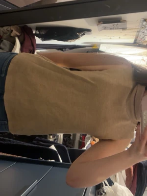Beige ärmlös polotopp - Säljer en beige polotopp i mjukt material. Toppen är ärmlös och har en hög krage. Perfekt att matcha med jeans eller kjol för en snygg outfit.