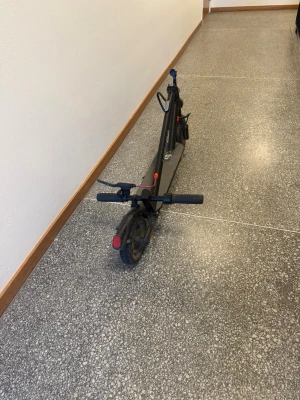 Svart elsparkcykel E-Wheels E2S V2 Long range - Säljer en svart elsparkcykel av modellen E-Wheels E2S V2. Den har hopfällbar design, handtag med greppvänligt material och tydliga reflexdetaljer. Perfekt för smidig transport i stan. Laddningsuttag och broms bak syns tydligt.