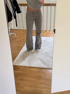 Gråa raka jeans  - Säljer ett par gråa jeans med rak passform. Sprättade längst ner