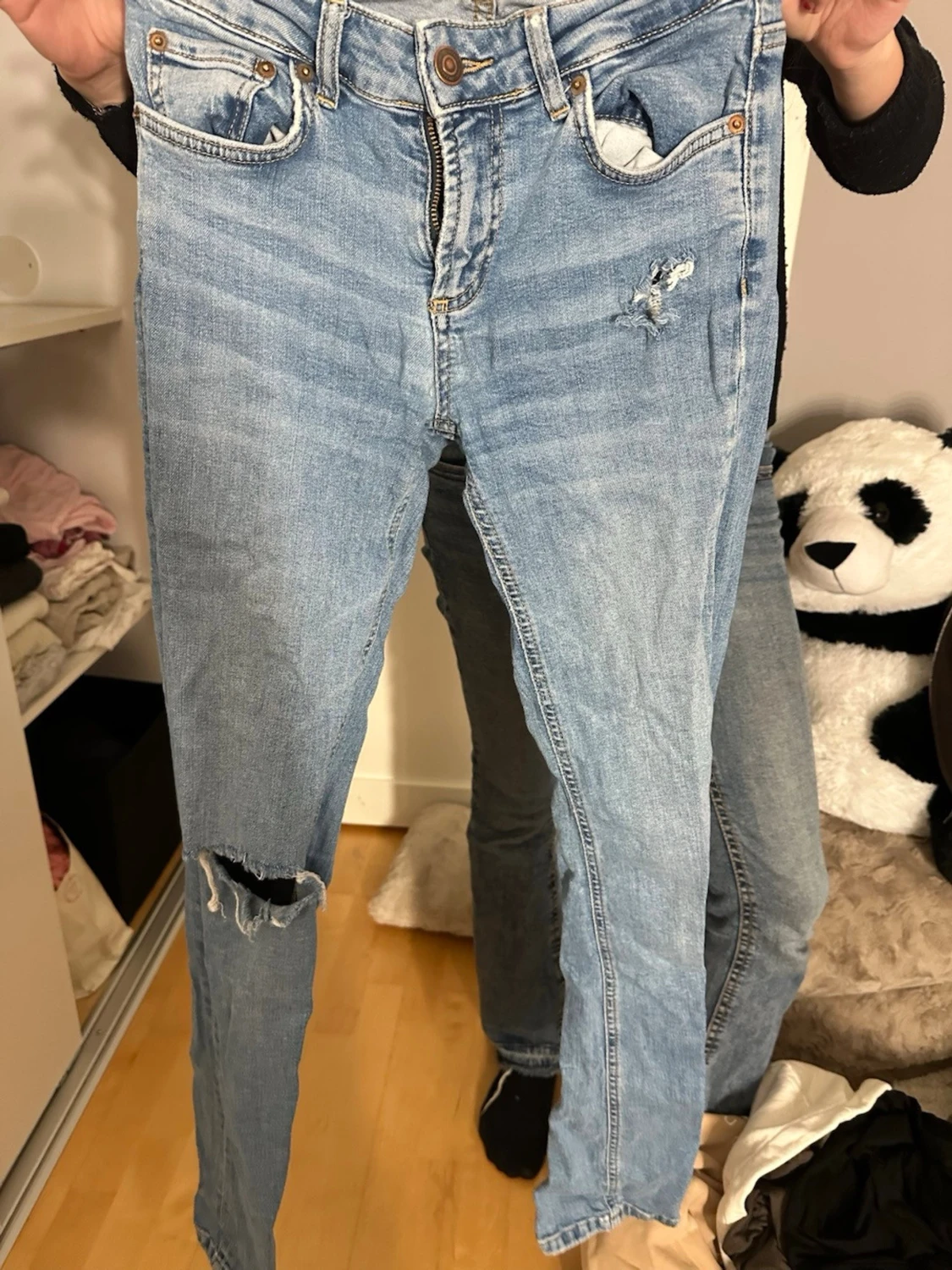 Ljusblå slitna jeans med hål