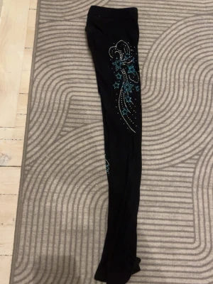 Svarta leggings med blå glittermönster - Ett par konståknings byxor med karisma 