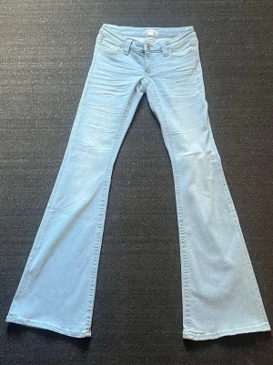 Ljusblå bootcut jeans - Ljusblå bootcut jeans, med låg midja och rhinestones på fickorna. De är ifrån Gina Young, i storlek S Tall. Säljer då dom är för stora för mig, dom är aldrig använda. nypriset på jeansen är egentligen 400kr. 🩵