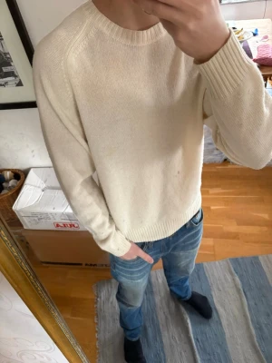 Vit stickad tröja  - Säljer en stilren vit stickad tröja från Uniqlo. Använd fåtal gånger och fortfarande i väldigt bra skick. Perfekt basplagg i garderoben och enkel att matcha till olika outfits.