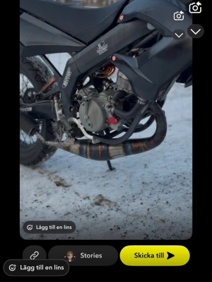 Svart crossmoped med trimdelar - Säljer en svart crossmoped med trimdelar och sportigt avgassystem. Mopeden har robust ram, synlig motor och detaljer i metall och plast. Märket Yamaha syns på ramen och avgassystemet har en cool blå-brun färgskiftning. Perfekt för dig som gillar att meka och köra offroad.