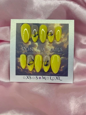 Lemon 🍋 (M);Medium Almond - Snygga handgjorda press-on naglar i en gul färg i en medium mandelform. Några naglar har nude bas med french, dekorativa citroner i blått och gult. Perfekt för dig som vill sticka ut med unika och trendiga naglar. M: 16 mm, 12 mm, 12,5 mm, 11,5 mm, 10 mm
