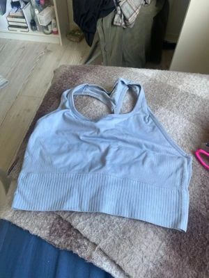 Ljusblå sport-bh från 157 - Ljusblå sport-bh från 157 med bred ribbad kant nedtill och brottarrygg. Tillverkad i ett stretchigt och mjukt material som ger bra stöd. Perfekt för träning eller som bekväm vardags-bh.