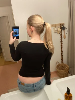 Svart långärmad topp med rundringning - Säljer en svart långärmad topp med snygg rundringad hals. Modellen är tight och figurnära, perfekt att styla med jeans eller kjol. Enkel och stilren design utan synliga detaljer eller mönster. Materialet känns mjukt och stretchigt.